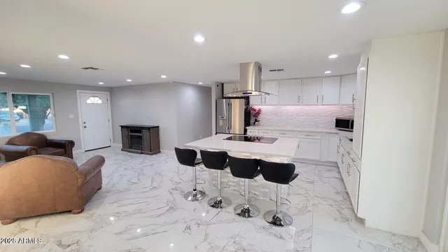 a living room with furniture and a view of kitchen