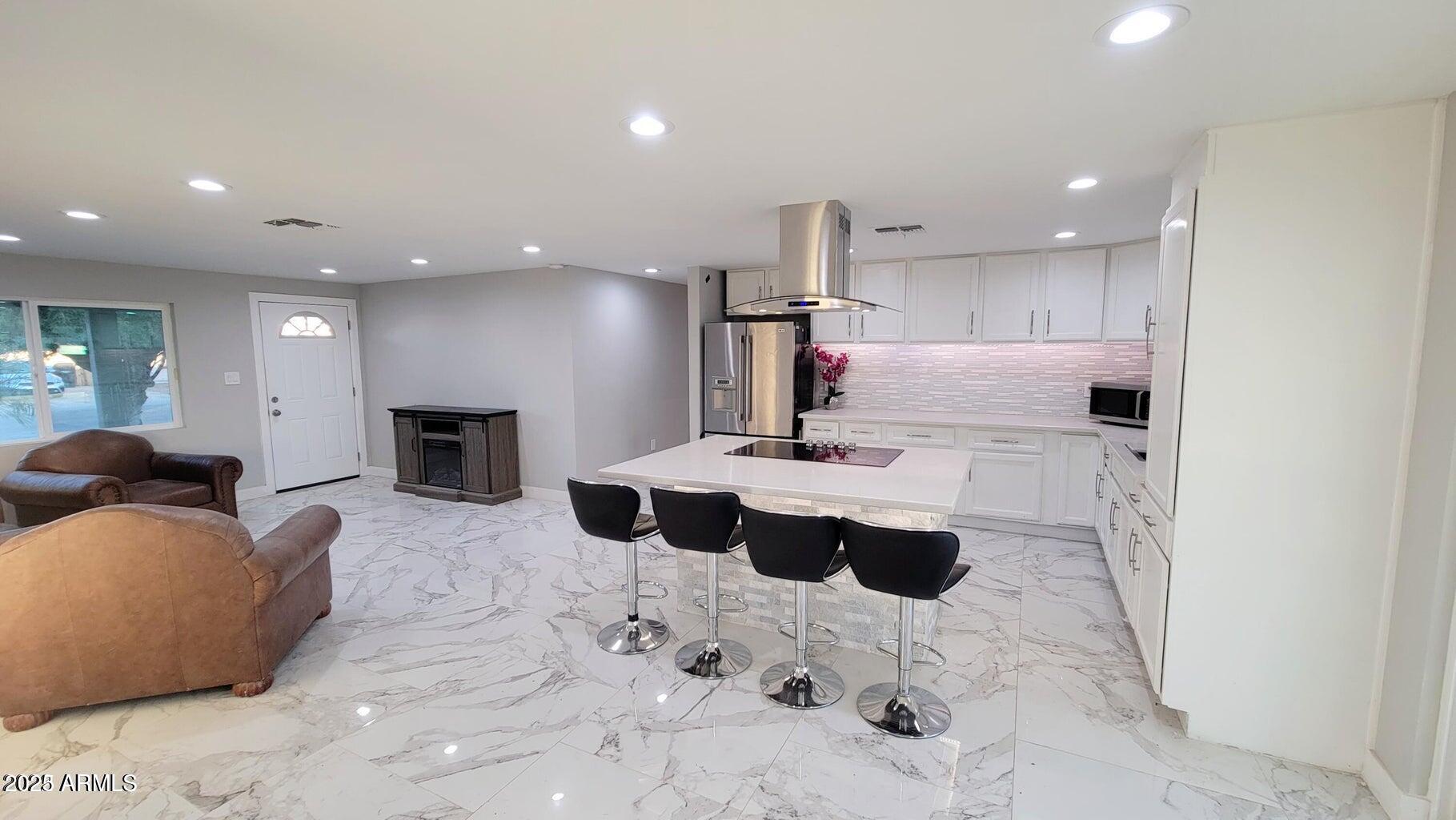 a living room with furniture and a view of kitchen