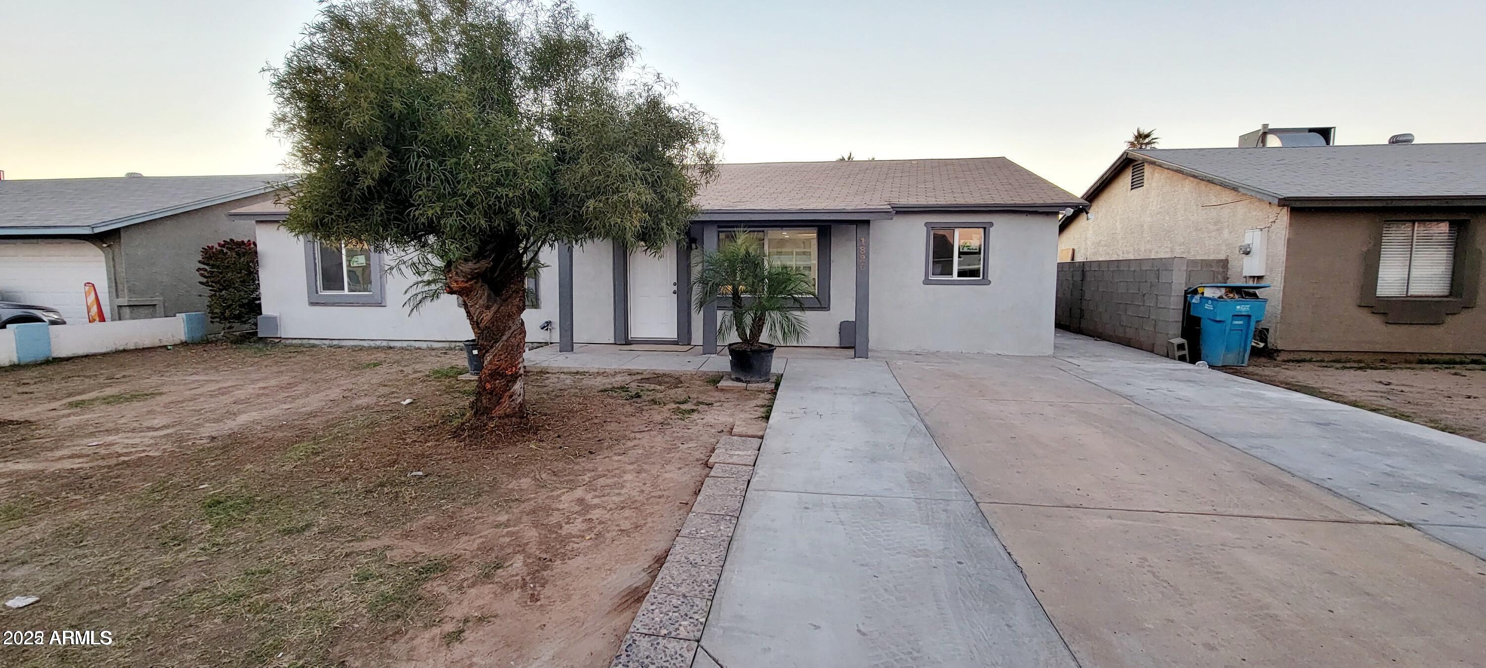 1826 North 73rd Avenue Phoenix, AZ 85035 - Photo 2 of 16 a front view of a house with a garden