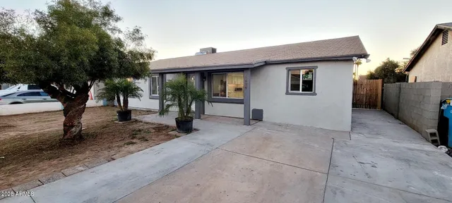 a view of a house with a yard and large tree