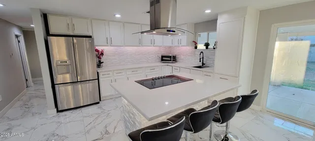 a kitchen with stainless steel appliances a stove a sink a refrigerator and cabinets