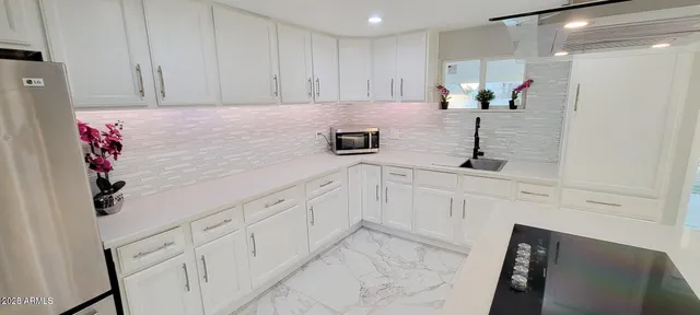 a kitchen with granite countertop white cabinets and white appliances
