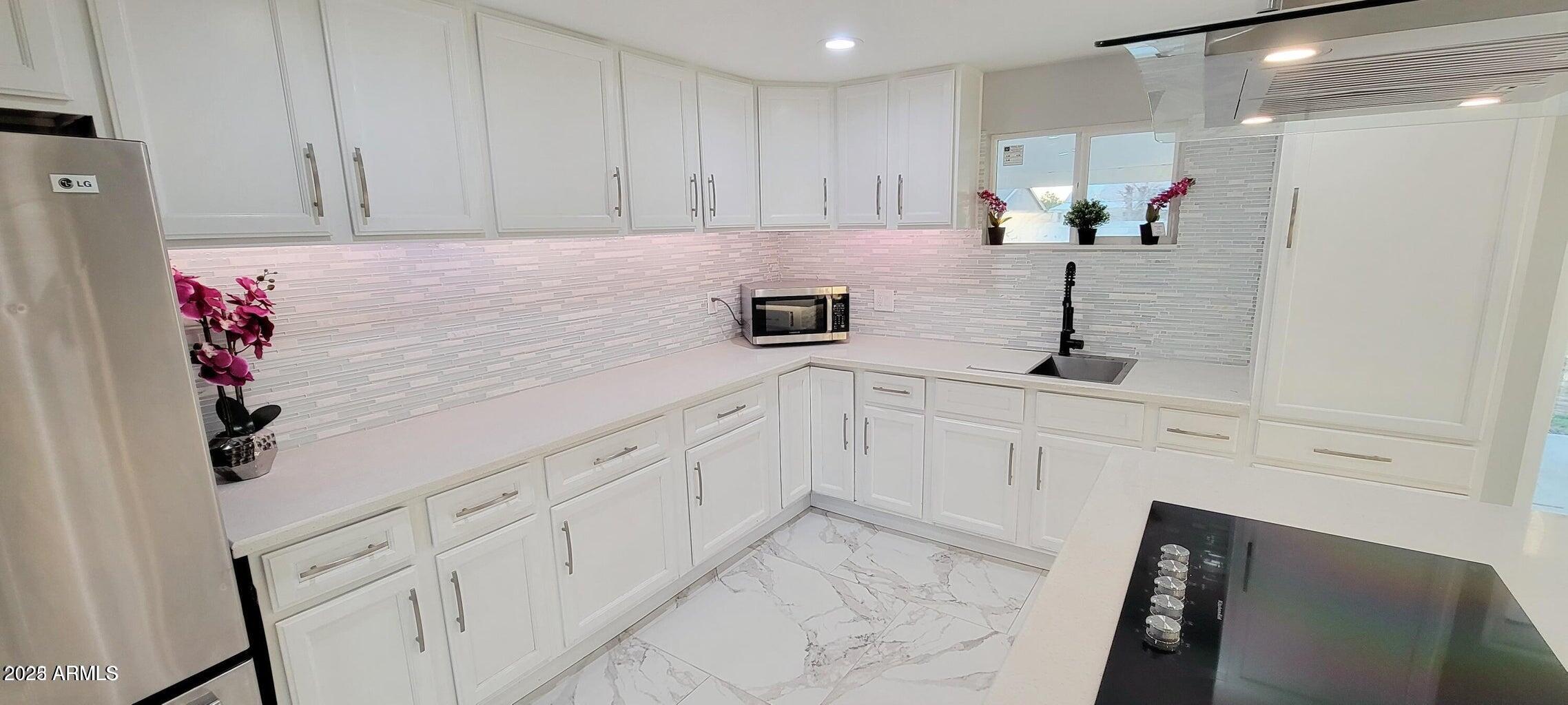 1826 North 73rd Avenue Phoenix, AZ 85035 - Photo 6 of 16 a kitchen with granite countertop white cabinets and white appliances
