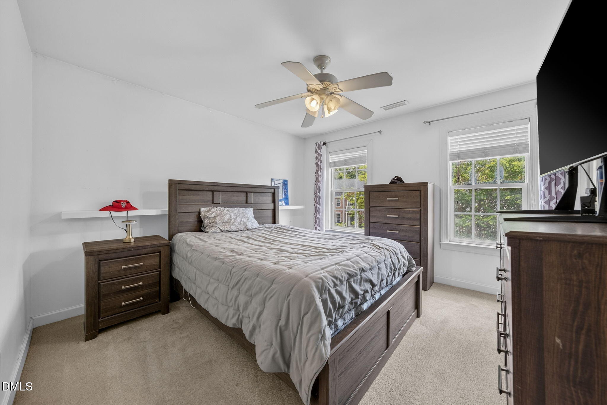 1258 Horsham Way Apex, NC 27502 - Photo 18 of 32 a bedroom with a bed dresser and a flat tv screen