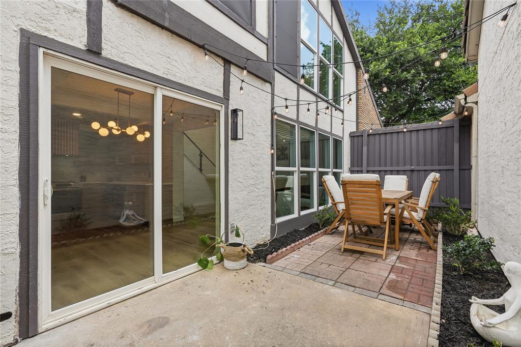 17118 Planters Row Addison, TX 75001 - Photo 10 of 18 Outdoor patio area featuring a brick paver section, privacy fencing, and a concrete pad