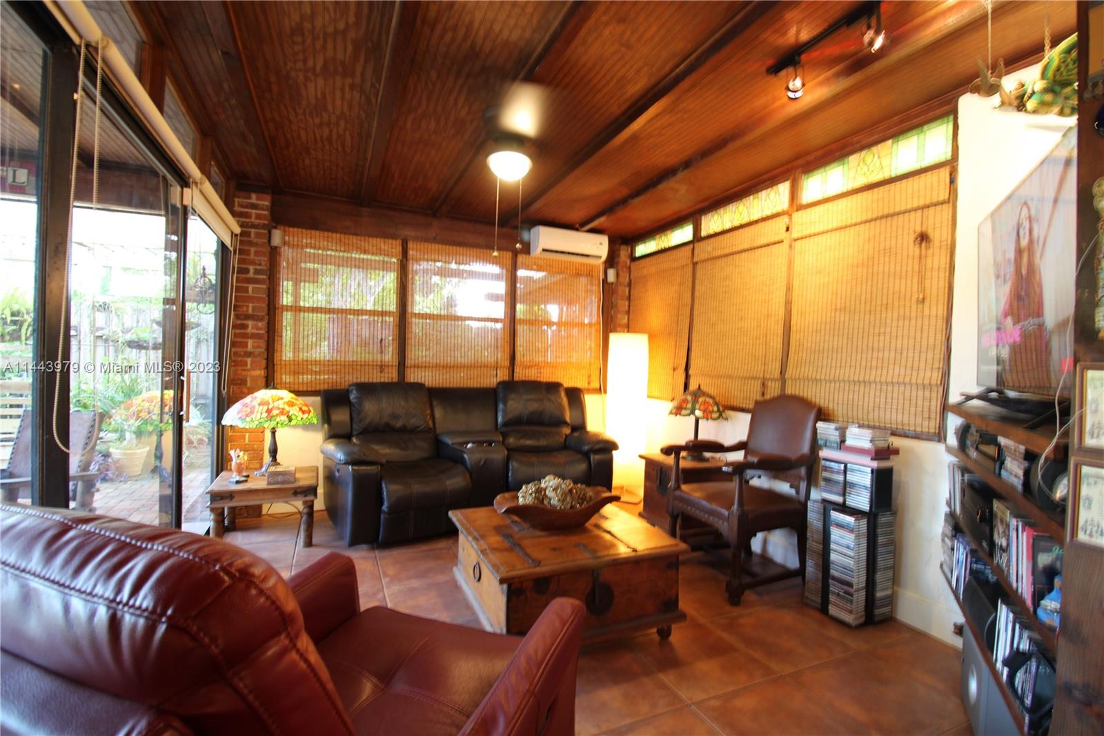 11370 Southwest 118th Street Miami, FL 33176 - Photo 8 of 26 a living room with furniture a fireplace and large windows