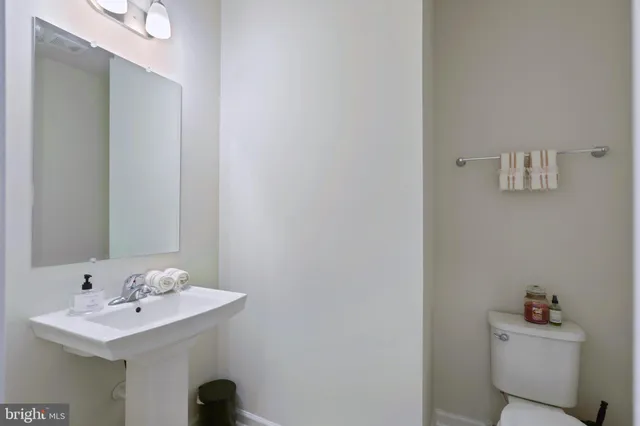 a bathroom with a sink a toilet and a mirror