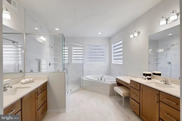 a bathroom with a double vanity sink a large mirror and a bathtub