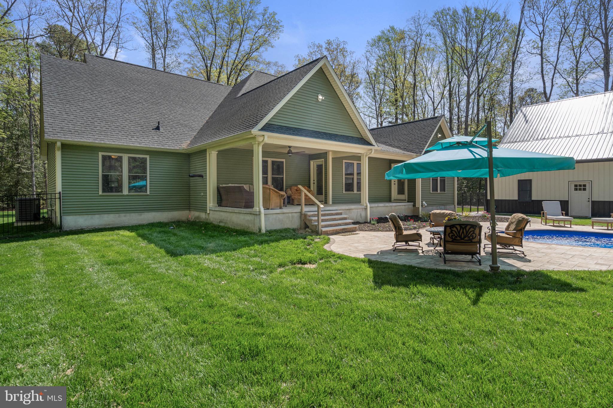 26750 Deep Branch Road Milton, DE 19968 - Photo 17 of 96 a patio with a table and chairs under an umbrella