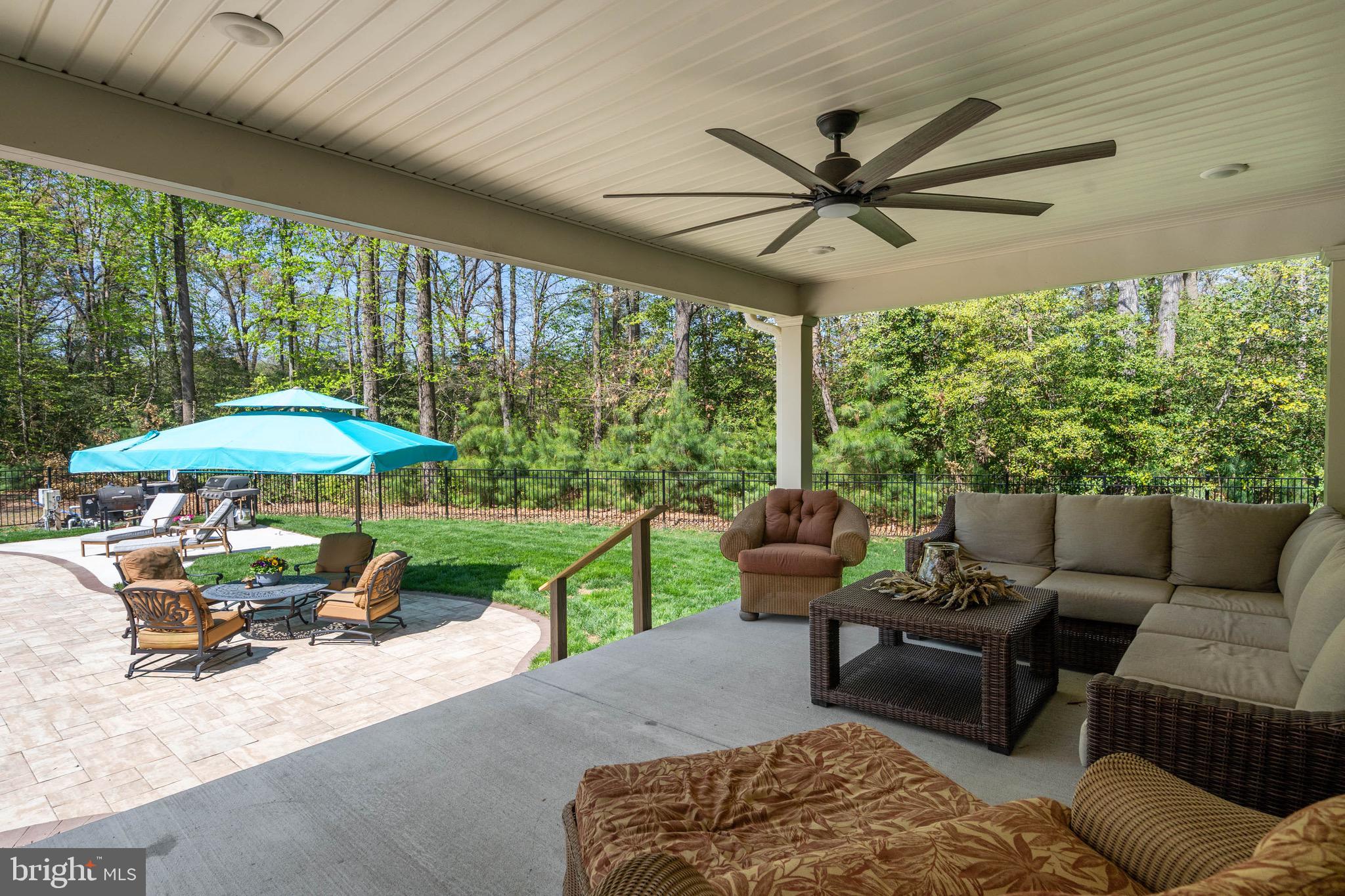26750 Deep Branch Road Milton, DE 19968 - Photo 19 of 96 a patio with a table and chairs under an umbrella with a large tree