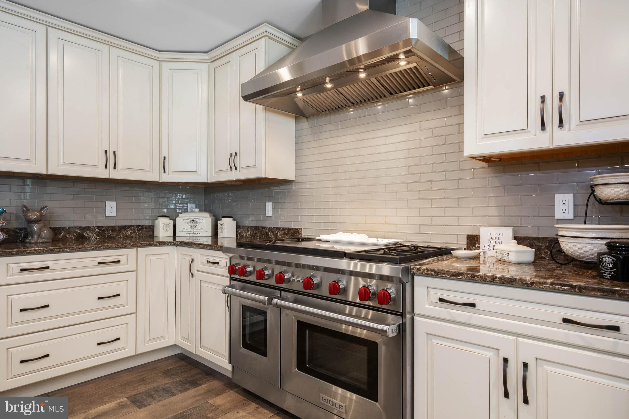 26750 Deep Branch Road Milton, DE 19968 - Photo 45 of 96 a kitchen with granite countertop a stove and white cabinets
