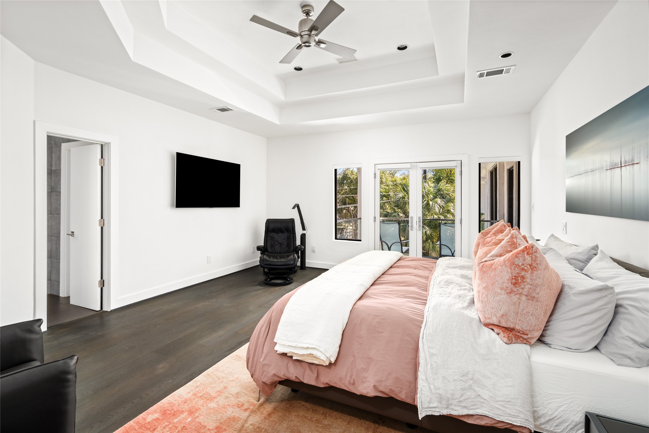 3703 Wroxton Road West University Place, TX 77005 - Photo 27 of 50 The Primary bedroom features a tray ceiling ample natural light from large windows and glass doors leading to a balcony.