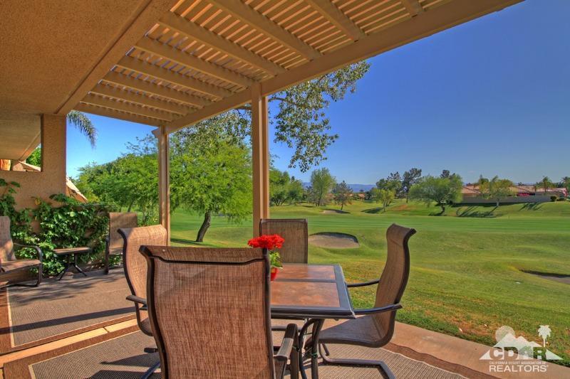 a view of a chairs and table in patio with a lake view