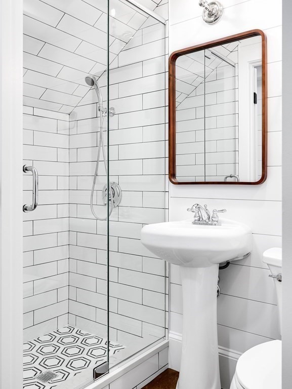 30 Copeland Street, Unit 1 Boston, MA 02119 - Photo 24 of 40 a bathroom with a sink a mirror and shower
