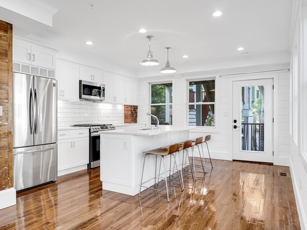 30 Copeland Street, Unit 1 Boston, MA 02119 - Photo 7 of 40 a kitchen with stainless steel appliances granite countertop a refrigerator a stove top oven and a refrigerator