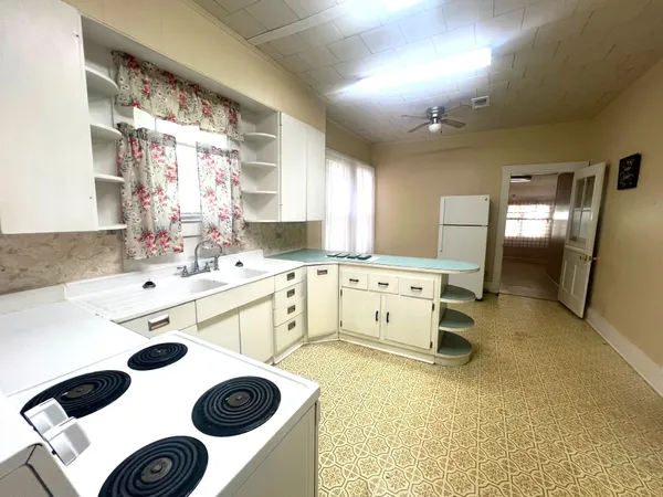 a kitchen with a stove and a white refrigerator