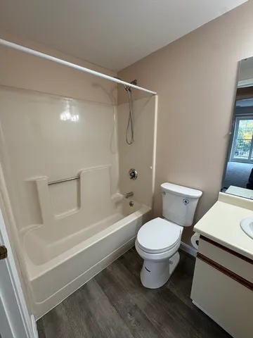 a white toilet sitting next to a bath tub and a shower