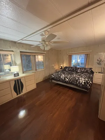 a bedroom with a bed a couch and large window with outer view