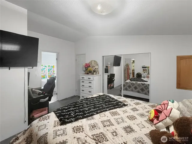 a bedroom with a bed and a flat screen tv