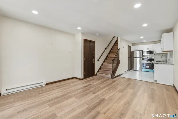 a view of a kitchen with wooden floor and stairs