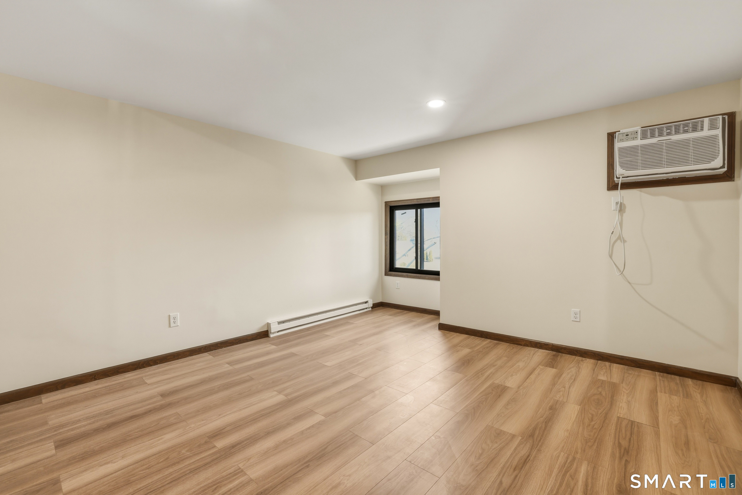 275 Broad Street, Unit 9 Meriden, CT 06450 - Photo 6 of 21 a view of an empty room with wooden floor and a window