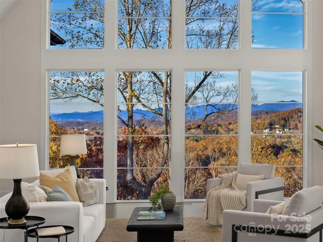 a living room with furniture a fireplace and a chandelier