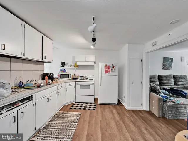 a kitchen with granite countertop a sink cabinets and stainless steel appliances