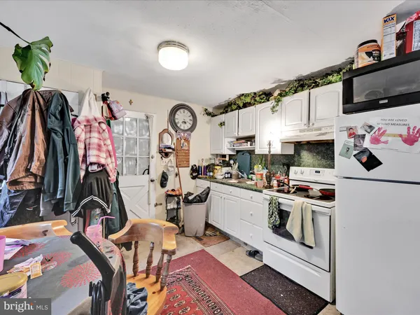 a view of a kitchen with fridge and workspace