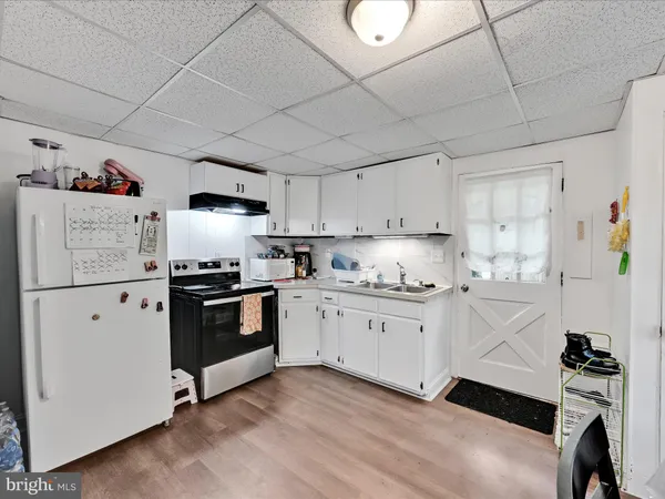 a kitchen with granite countertop white cabinets and white appliances