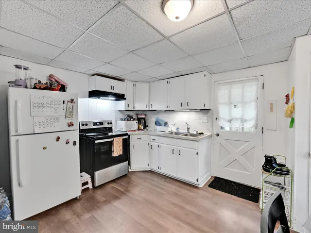 a kitchen with granite countertop white cabinets and white appliances