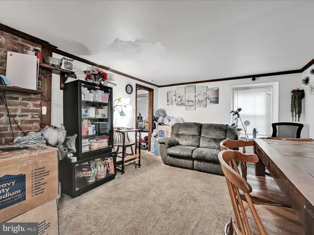 a living room with furniture a rug and white walls