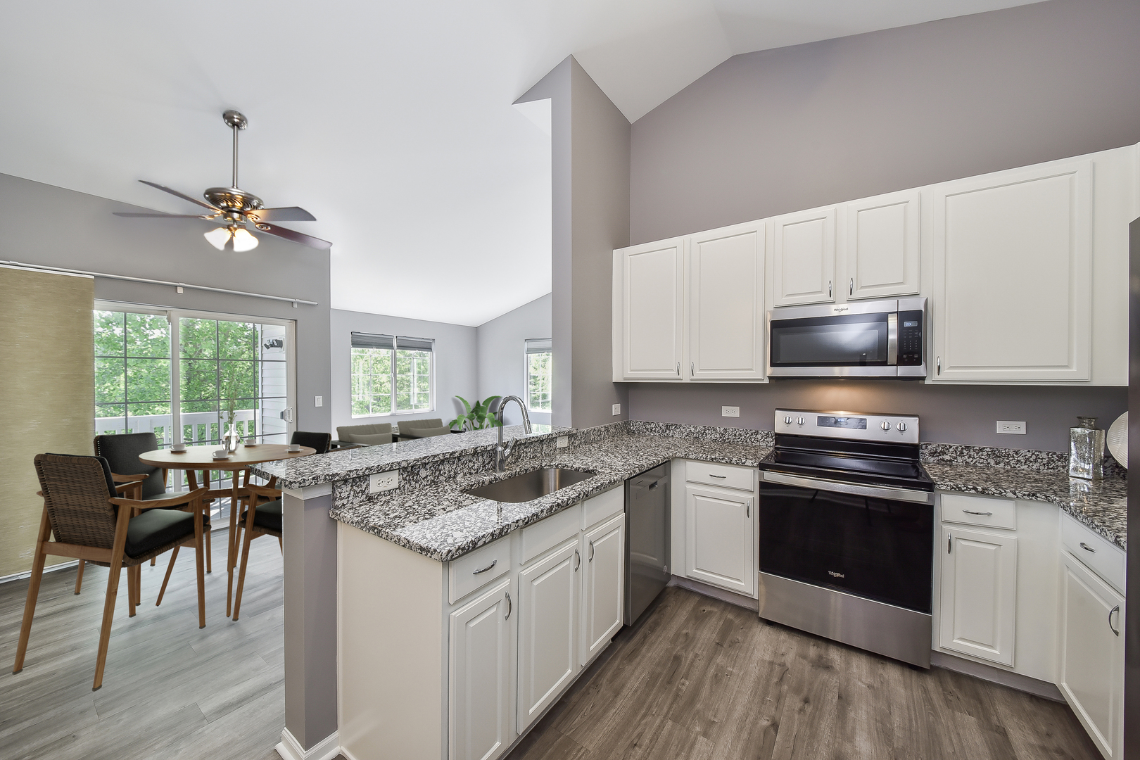 1556 McClure Road, Unit 1556 Aurora, IL 60505 - Photo 5 of 17 a kitchen with stainless steel appliances granite countertop a stove a sink and a microwave