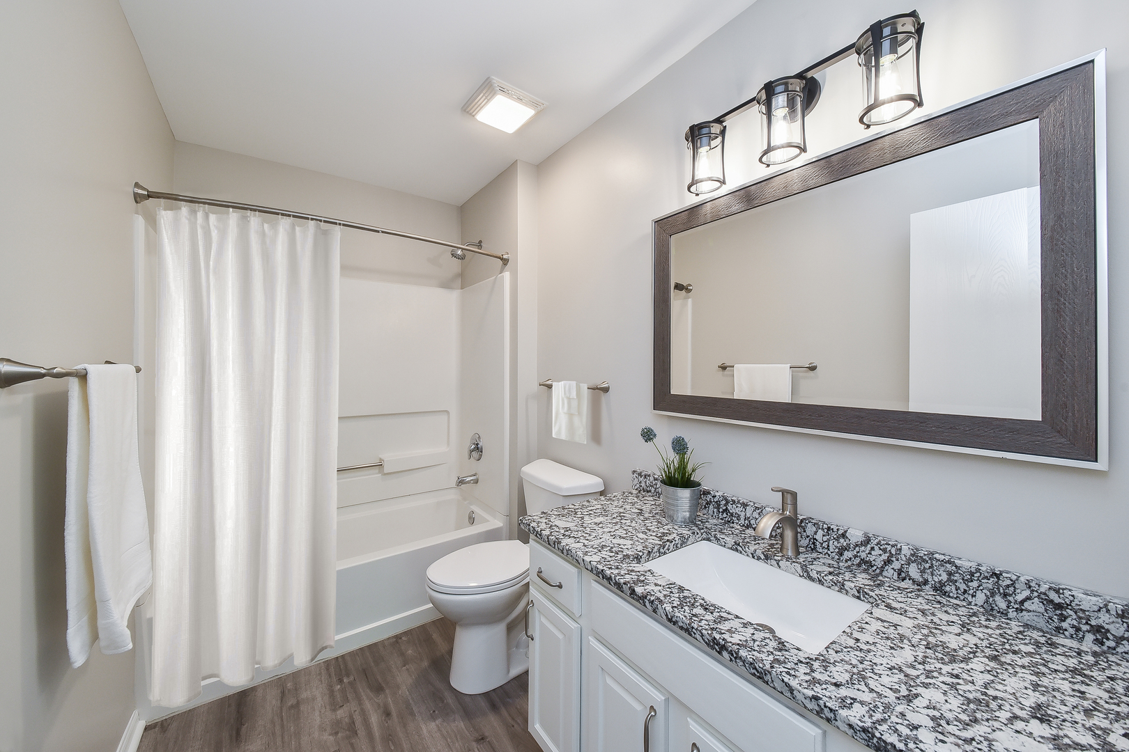 1556 McClure Road, Unit 1556 Aurora, IL 60505 - Photo 9 of 17 a bathroom with a granite countertop sink vanity mirror bathtub shower and a toilet