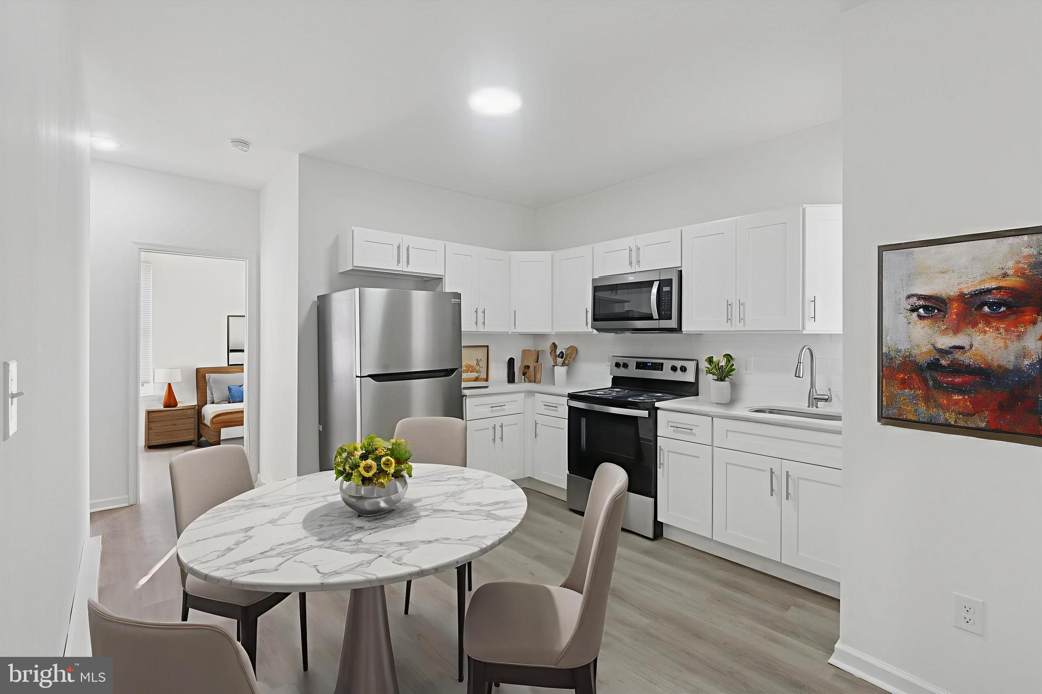 a kitchen with stainless steel appliances granite countertop a dining table and chairs