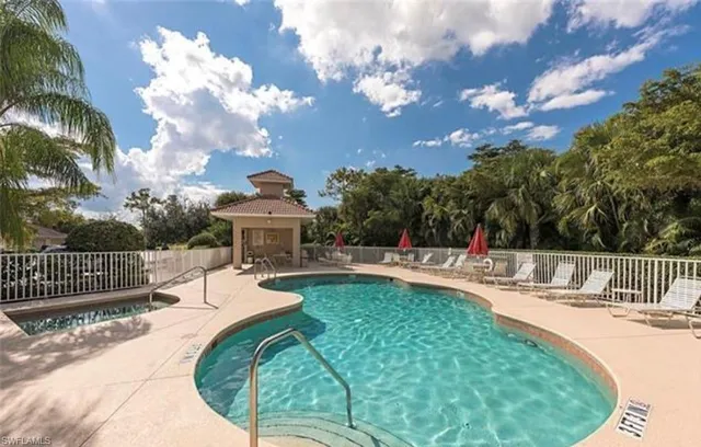 a view of a swimming pool and lounge chairs in back yard