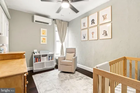 a living room with furniture and a baby crib