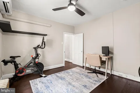 a room with gym equipment and wooden floor