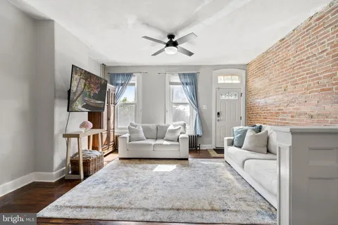 a living room with fireplace furniture and a rug