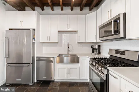 a kitchen with appliances a refrigerator and cabinets