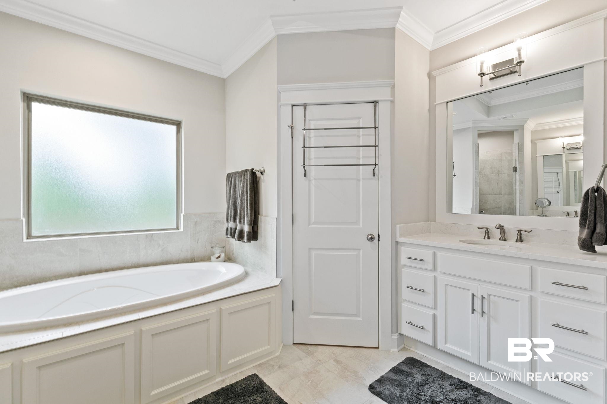 13233 Ibis Boulevard Daphne, AL 36527 - Photo 30 of 100 Recessed soaking tub with frosted glass window, white vanity with stone-finish countertop, undermount sink, and polished chrome hardware