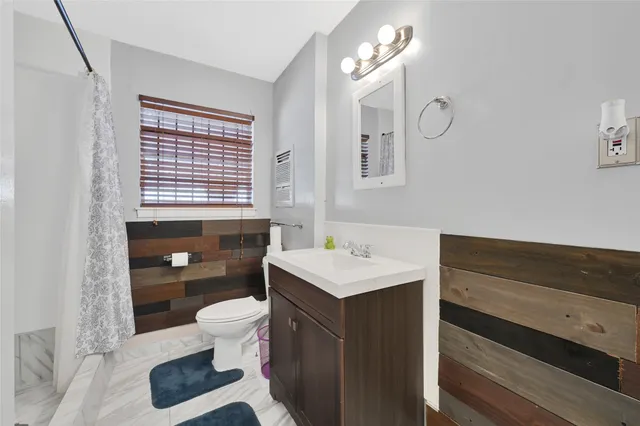 a bathroom with a sink a toilet a mirror and shower