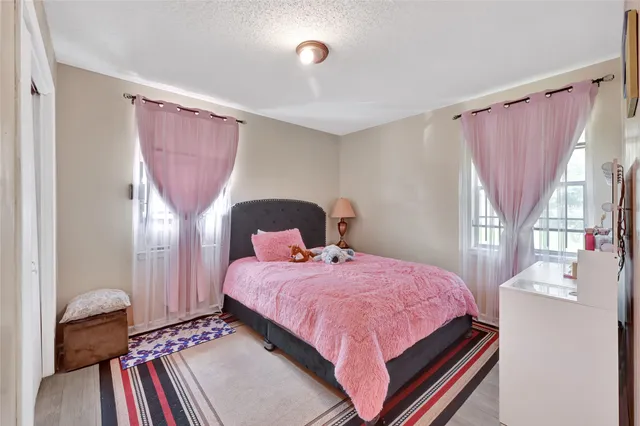 a bedroom with a bed next to a window with outer view and chair
