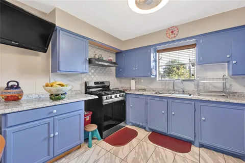 a kitchen with a sink stove and cabinets