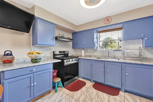 a kitchen with a sink stove and cabinets