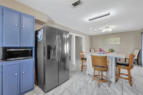a kitchen with stainless steel appliances granite countertop a dining table and chairs