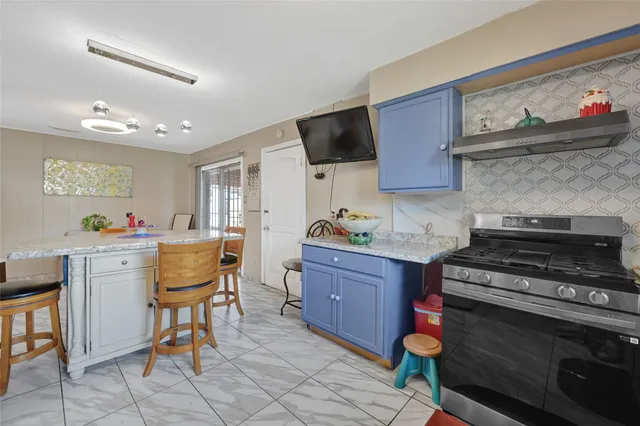 a kitchen with granite countertop stove top oven and cabinets