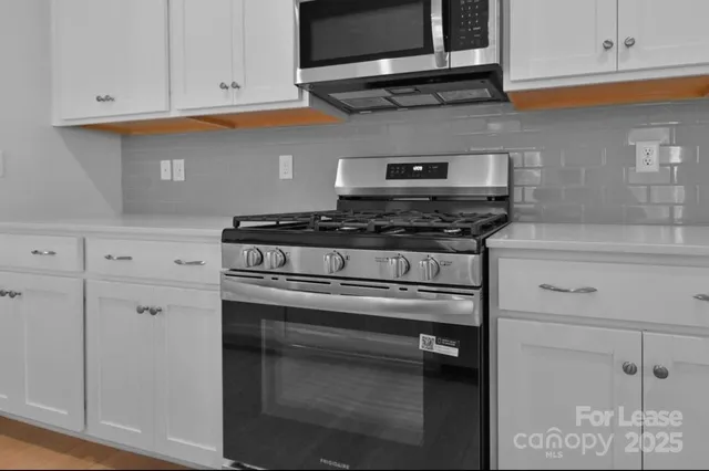 a stove top oven sitting inside of a kitchen