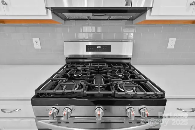 a white stove top oven sitting inside of a kitchen