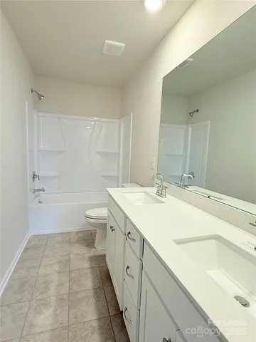 a spacious bathroom with a granite countertop sink a toilet and shower
