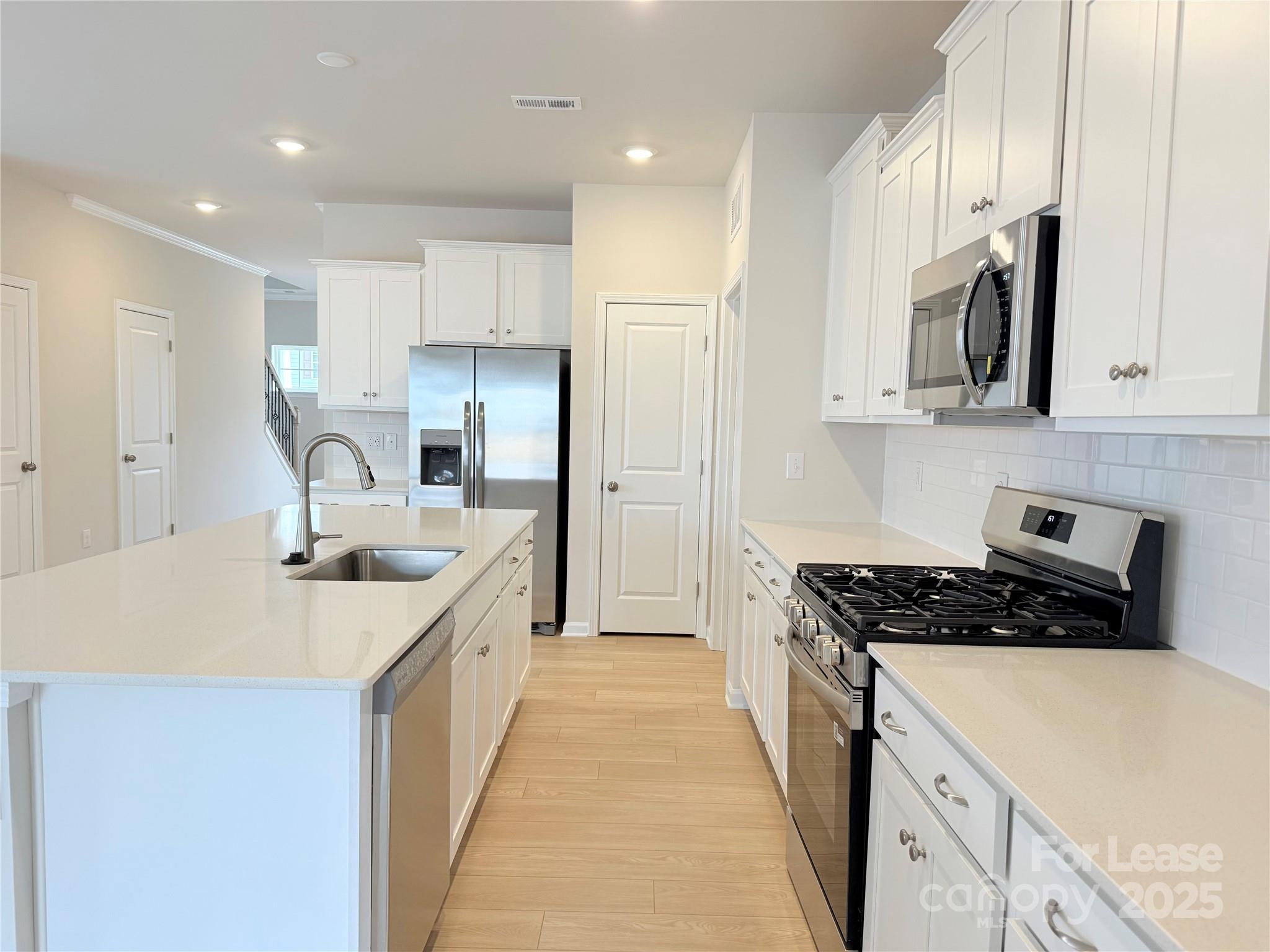 4326 Shimmering Stone Way Maiden, NC 28650 - Photo 10 of 27 a kitchen with stainless steel appliances a sink stove and cabinets